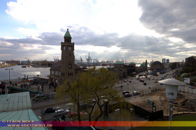 307 - Die St. Pauli-Landungsbr�cken liegen im Hamburger Stadtteil St. Pauli zwischen Niederhafen und Hamburger Fischmarkt an der Elbe. Bei den Landungsbr�cken handelt es sich um eine gro�e Anlegestelle f�r Fahrgastschiffe am Nordrand des Hamburger Hafens. An ihrem westlichen Ende befindet sich der n�rdliche Eingang zum Alten Elbtunnel. Den �stlichen Abschluss des Geb�udekomplexes bildet der Pegelturm. Auf halber H�he des Turmes auf der Elbseite ist oben in der Mauer ein Wasserstandsanzeiger eingelassen, der �ber den aktuellen Stand der Tide informiert. In seiner zweiten Funktion ist der Pegelturm auch Uhren- und Glockenturm. Das Zifferblatt ist weithin sichtbar. Die Glocke erklingt zur vollen und halben Stunde. Die Landungsbr�cken sind auch ein Verkehrsknotenpunkt von S-Bahn, U-Bahn und HADAG-Schiffen sowie eine Touristenattraktion, da von hier aus eine interessante Sicht auf die Norderelbe und den Hafen besteht.